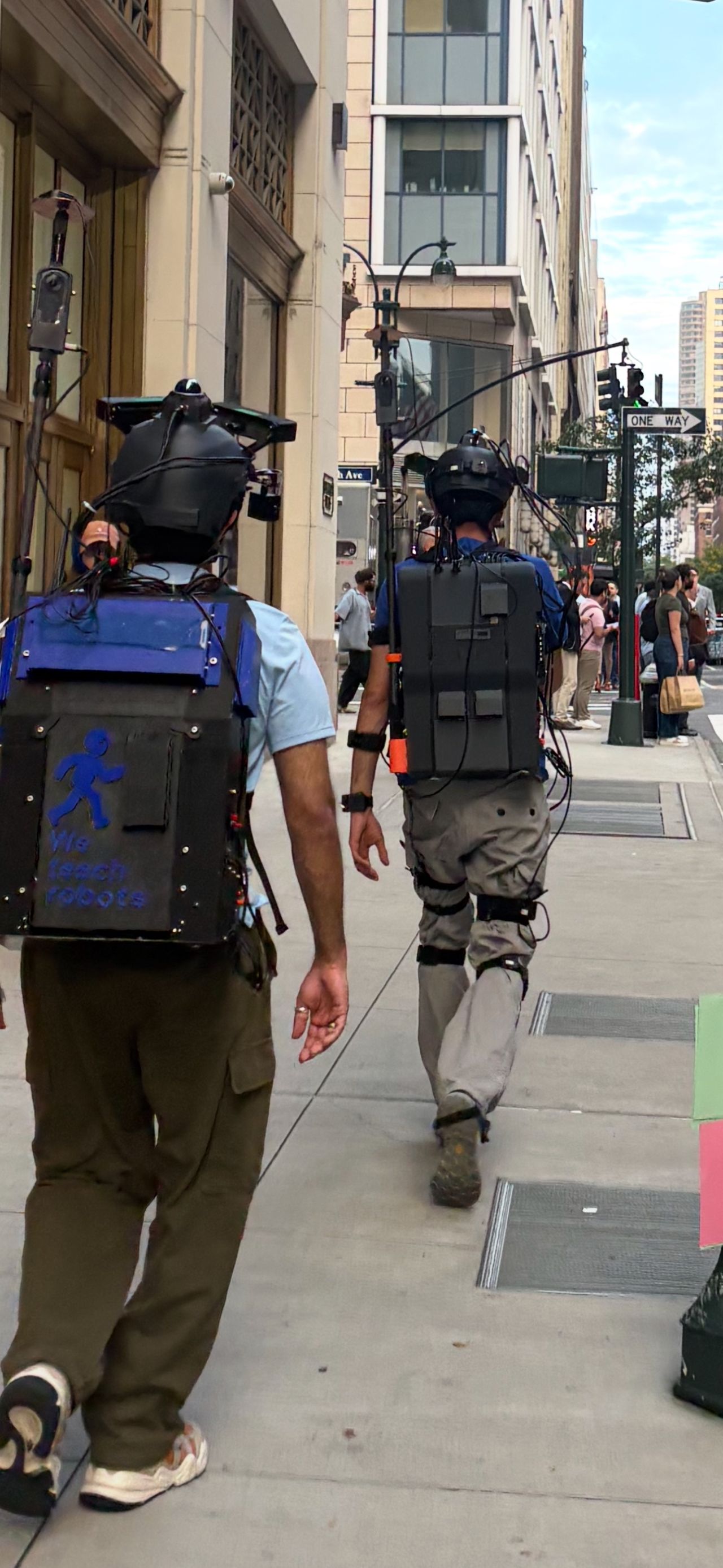 Two operators wearing THX rigs walking down a busy New York sidewalk